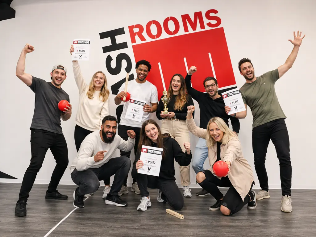Neun Gäste jubeln vor der BASH-ROOMS-Wand, in der Mitte ein Pokal, mehrere halten Urkunden für den ersten Platz